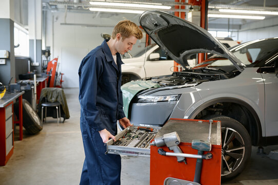 Automobile technician taking instrument from toolkit box