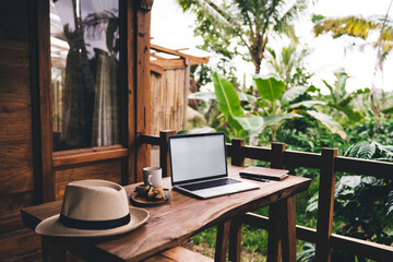 Workplace with laptop notebook hat and tea set