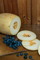 Still life with melon and blueberries on a wooden background