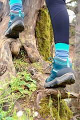 Woman wearing outdoor shoes in the nature, climbing and trekking theme