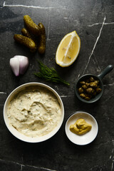 Classic Tartar Sauce with it ingredients on dark stone or marble background. Mayonnaise with dill and pickled cucumbers with lemon. Top view food photo. Flatlay