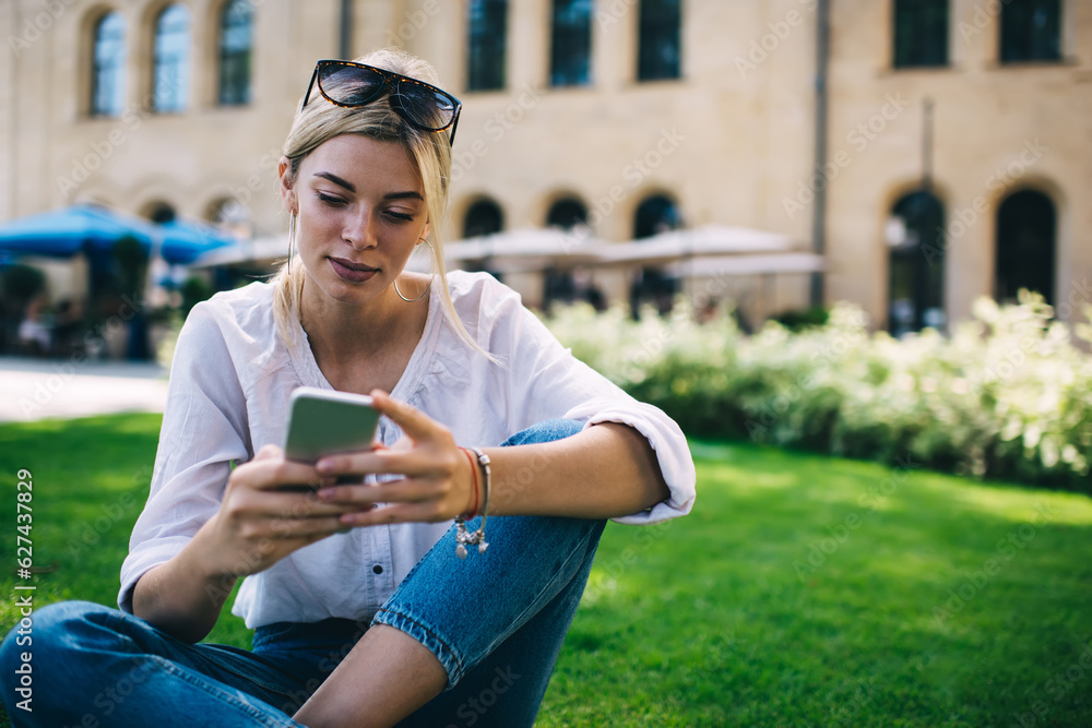 Poster attractive young blogger watching web video content in networks while browsing social media in summe