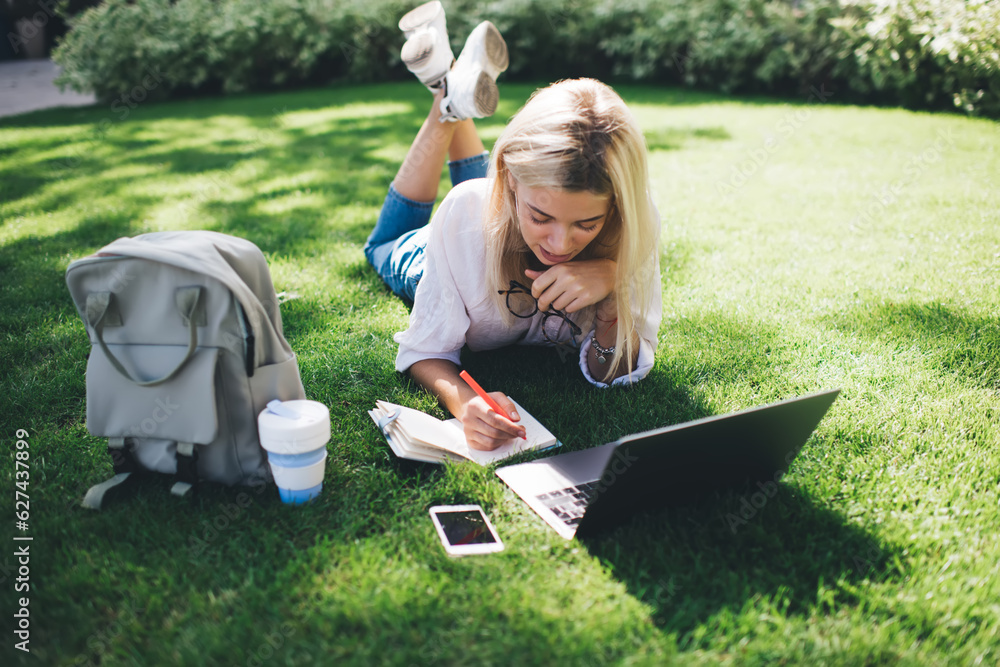 Poster caucasian female freelancer with digital laptop computer making informative notes in textbook planne