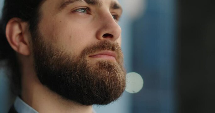 Portrait of businessman with beard and long hair, opening his eyes. 