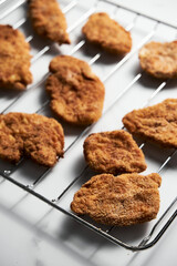 Close Up of Baked Chicken Schnitzel in breadcrumbs schnitzel on grid. 