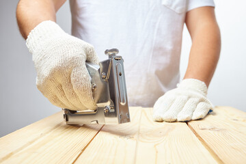 Male installer using stapler for wooden plank