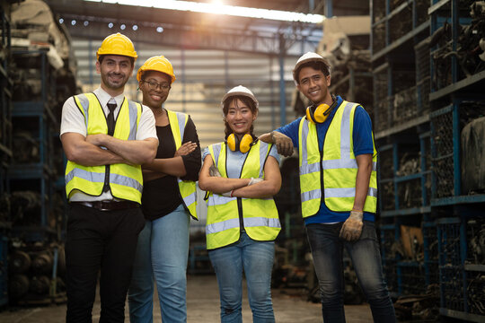 portrait group of engineer employee team staff group diversity worker together in dirty metal factory workshop background