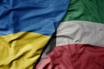 big waving national colorful flag of ukraine and national flag of kuwait .