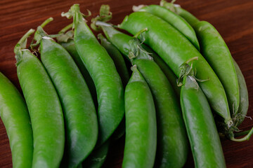Green pea pods on wooden table. Ripe pea.