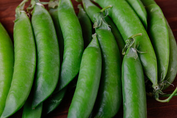 Green pea pods on wooden table. Ripe pea.