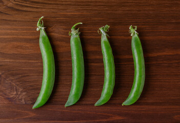 Green pea pods on wooden table. Ripe pea. Top view.