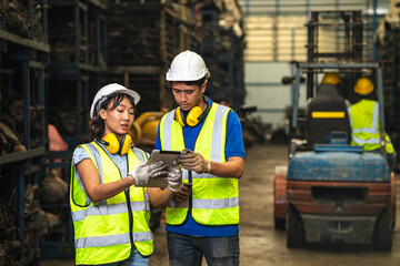 Engineer employee team women worker working together with man work in dirty junkyard old used auto car part warehouse for recycle or repair