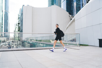 Cheerful sportive woman walking on street