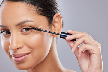 Portrait, mascara and woman with brush in studio for makeup, cosmetics and results on grey...