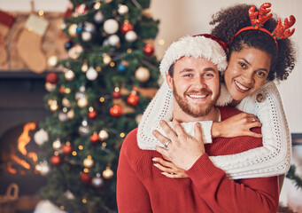 Christmas, portrait and happy couple in home, hug and bonding together. Xmas, smile and face of man with African woman, interracial and enjoying quality time for party, celebration and winter holiday - obrazy, fototapety, plakaty