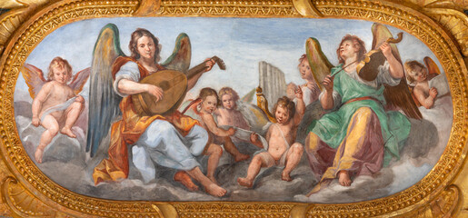 Fototapeta na wymiar GENOVA, ITALY - MARCH 5, 2023: The fresco of angels choir with the music instrumenst in the church Chiesa del Gesu by Giovanni Carlone from 17. cent.