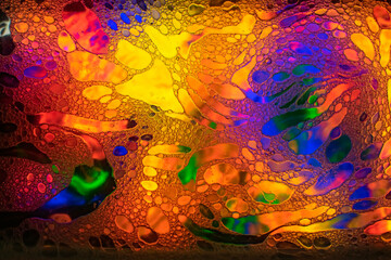 Oil and soap bubbles on water, abstract background.