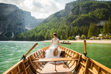 Fototapeta na wymiar Beautiful female model in her white wedding dress at Lago di Braies