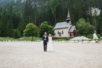 Beautiful married couple at the church next lake braies in Italy, the Dolomites
