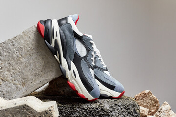 Modern sneakers for travelling and walking. Casual shoe on podium like rocky mountain peak. Shoes...