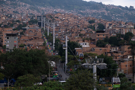 Public transit cable car gondolas carrying passengers to and from mountainous neighborhoods in suburban areas of South America. Accessible electric public transport concept. Medellin, Columbia.