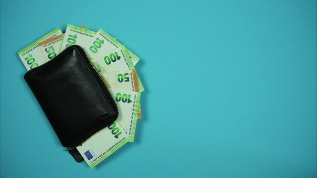 Euro banknotes appear from black leather wallet. Cash money income. Stop motion