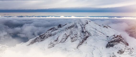 Fototapeta na wymiar Mt Baker covered in snow and clouds. Aerial landscape nature background.