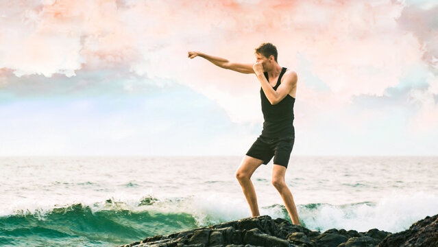 young man boxing against the backdrop of the sea - Powered by Adobe