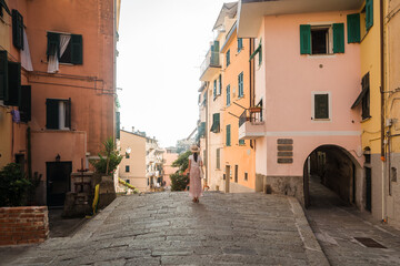 Beautiful female model in front he of the colorful city of Riomaggiore, Cinque Terre, Italy