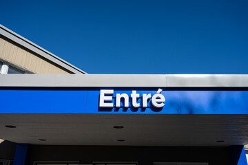 Entre sign on blue background above an entrance.