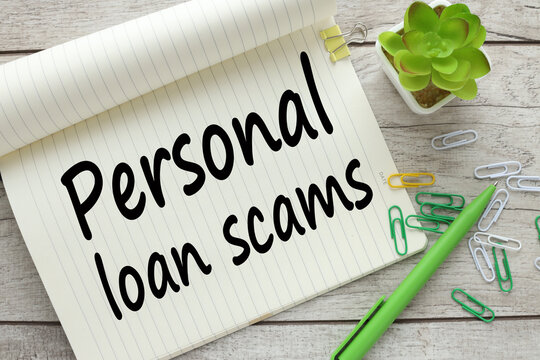open notebook near a plant in a pot. words Personal Loan Scams