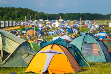 Travelers and camping tents on meadow in countryside
