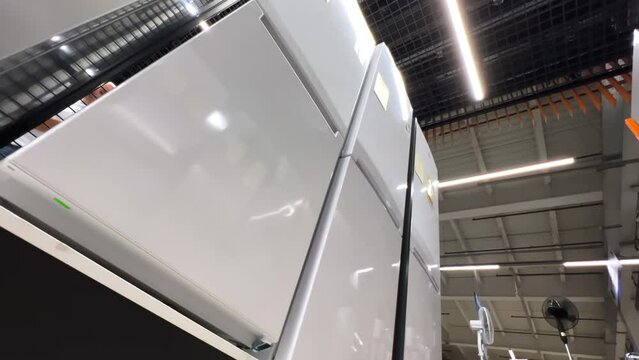 New refrigerators lined up in a home appliance store. Extreme wide low angle view
