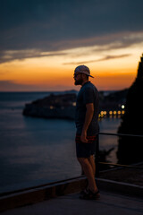 Fototapeta premium Beautiful male model on the streets of Dubrovnik. Amzing golden sunset.