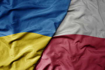 big waving national colorful flag of ukraine and national flag of poland .