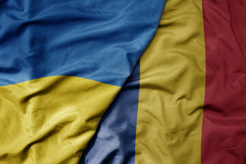 big waving national colorful flag of ukraine and national flag of romania .