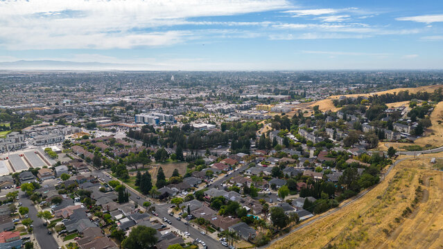 Aerial images over a neighborhood in Hayward, California with a blue sky and room for text.