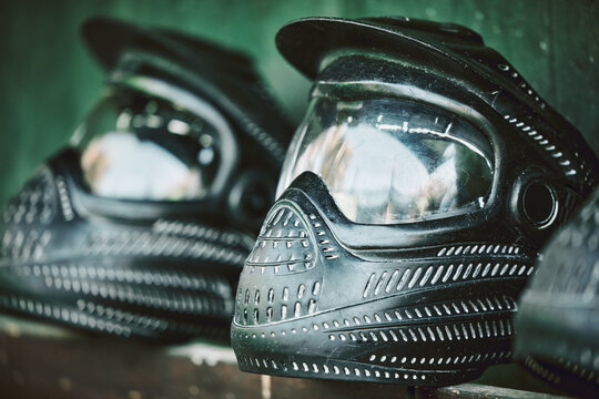 Mask, helmet and paintball with still life equipment on a table outdoor ready for combat training or war games. Safety, sports and military protection with uniform headwear closeup for competition