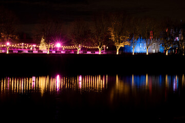 Hampton Court Palace ice rink colourfully lit at night in winter