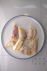 Fresh varenyki with butter on plate, top view. Sweet food with cherry, ready to eat