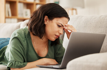 Woman, home and headache with laptop and remote work stress on a sofa feeling frustrated. House, female person and confused from computer problem with anxiety from online website project on a couch