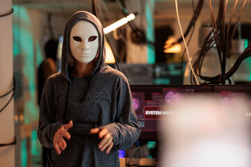 Hacker in mask hacking computer system password, breaking into online server, anonymous attacking database. Cybercrime, woman hacker stealing information portrait at night time