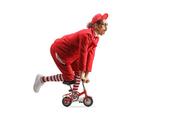 Funny entertainer in a red suit riding a small bike