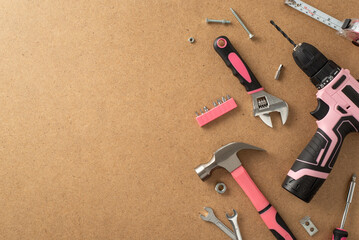 Acknowledging the vital role of women in labor on Labor Day. Above view photograph featuring a pink building tools on wooden isolated backdrop, allowing place for advertising or text placement