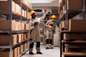 Storehouse manager checking products stock supply in shop logistics department warehouse. African...