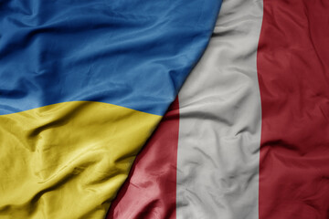big waving national colorful flag of ukraine and national flag of peru .