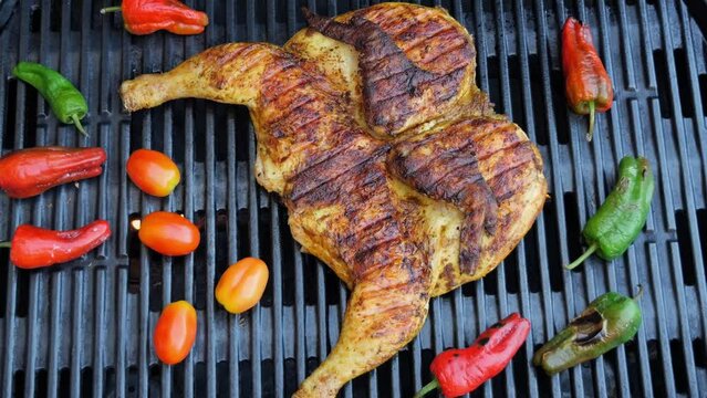 Cooking fried roast Chicken Tabaka on grill with vegetables.Tobacco chicken