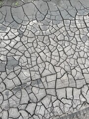 Cracked black dry dirt texture. Natural background