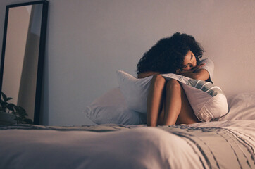 Sad, woman and bed with depression and pillow hug at home with anxiety. House, female person and...