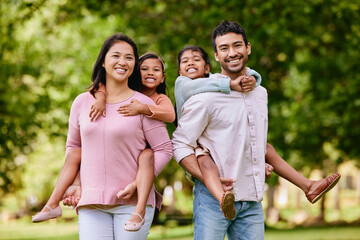 Piggyback, portrait and asian family in a park happy, smile and having fun while bonding outdoor. Love, hug and face of parents carrying children in a forest, cheerful and playing games in nature